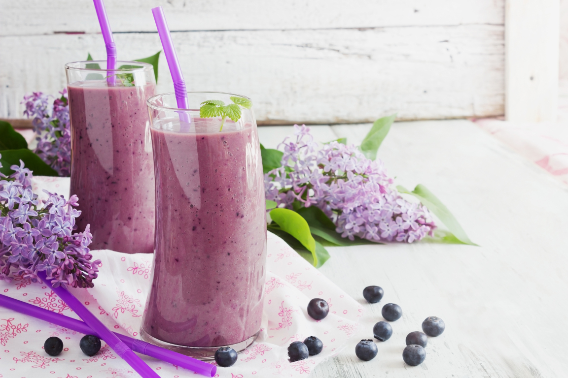 fresh smoothie with blueberries in a glass on a white wooden background. ripe blueberries. health and diet  beverage. selective focus